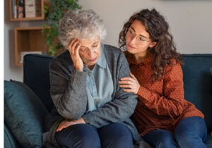 Young woman consoling upset grandmother